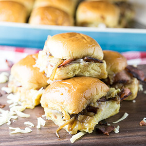 Tiny party sandwiches with bacon, melted cheese, caramelized onions, and a buttery sauce will make all your guests smile-if you choose to share. | Recipe from Chattavore.com