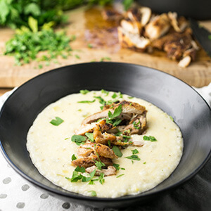 Fall is coming up, and that means it's time for warm comforting meals. These cheesy, creamy grits topped with Cajun chicken thighs fit the bill! | recipe from Chattavore.com