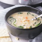 A bowl of chicken and gnocchi soup with crackers